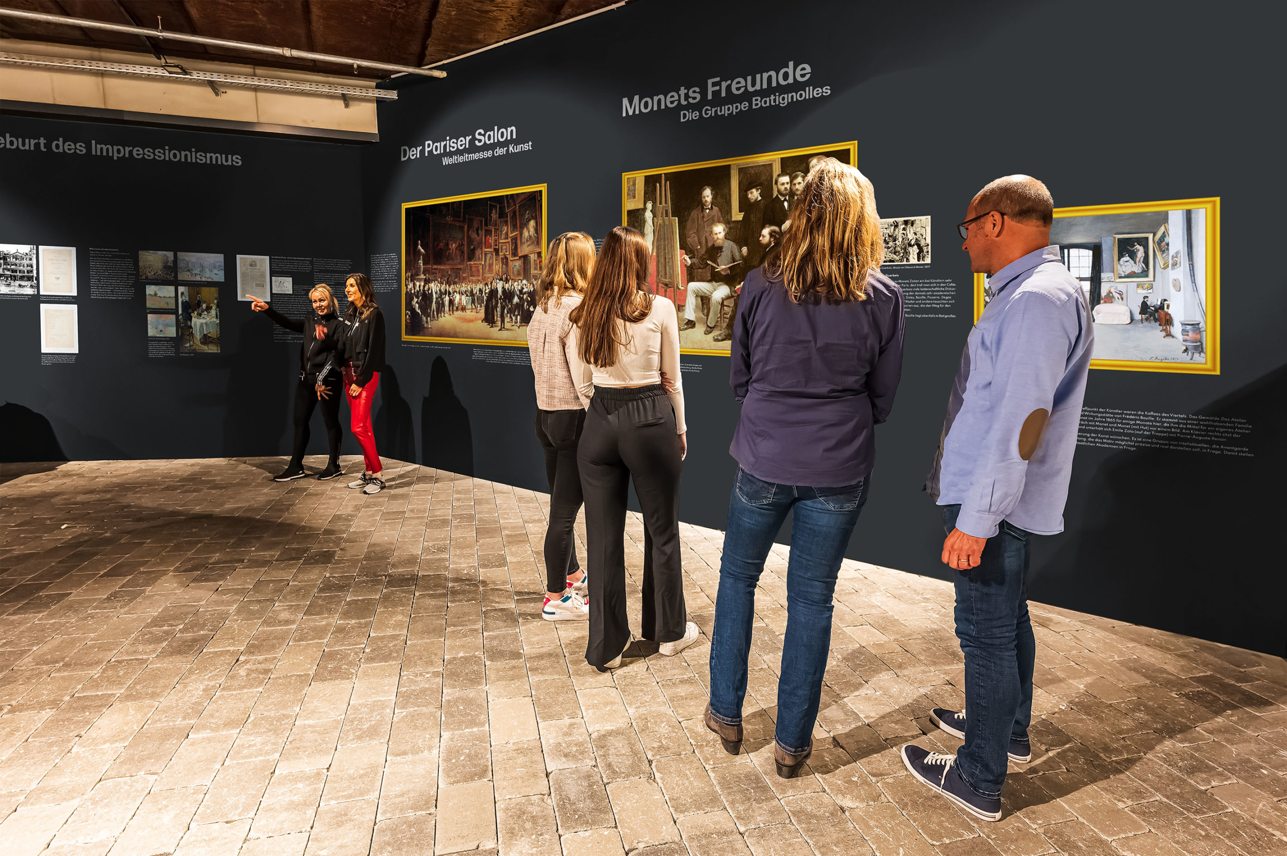 Besucher in der Monet Ausstellung betrachten Bilder im goldenen Rahmen